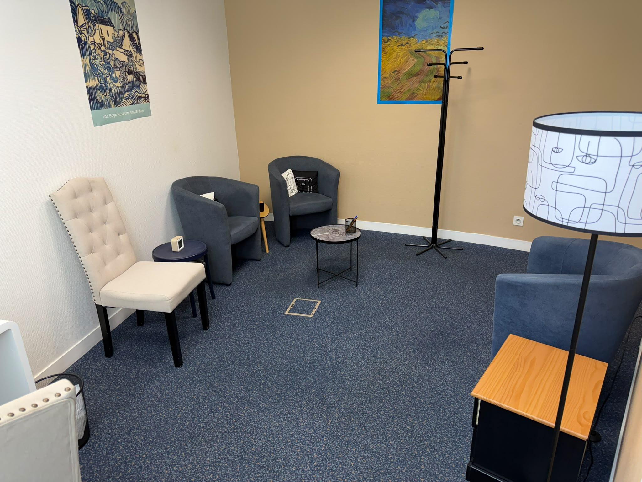L'espace de consultation : fauteuils bleus, chaises crème et affiches Van Gogh